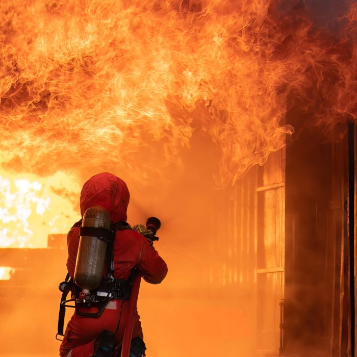 A fire fighter putting out a house fire